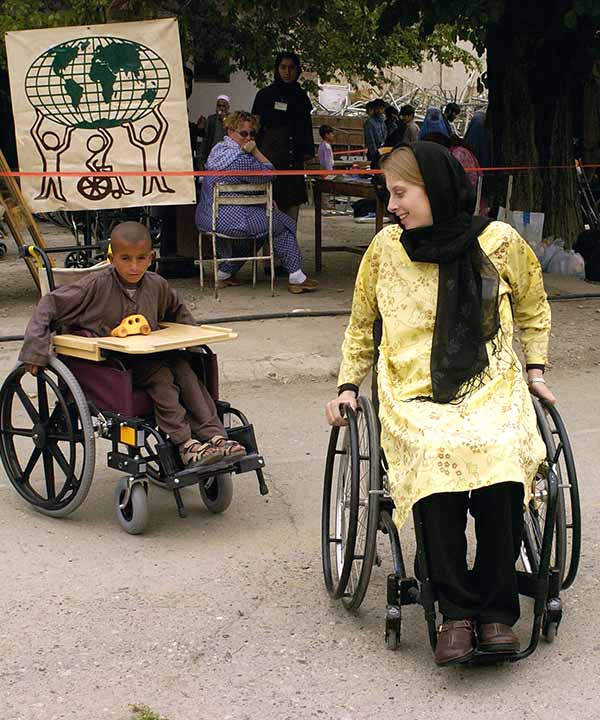 young woman and a child each maneuver a wheelchair