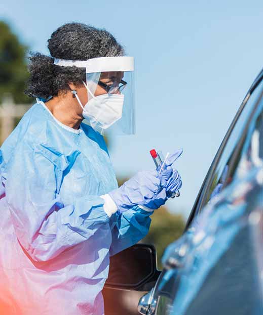 medical professional administers covid test to passenger of vehicle