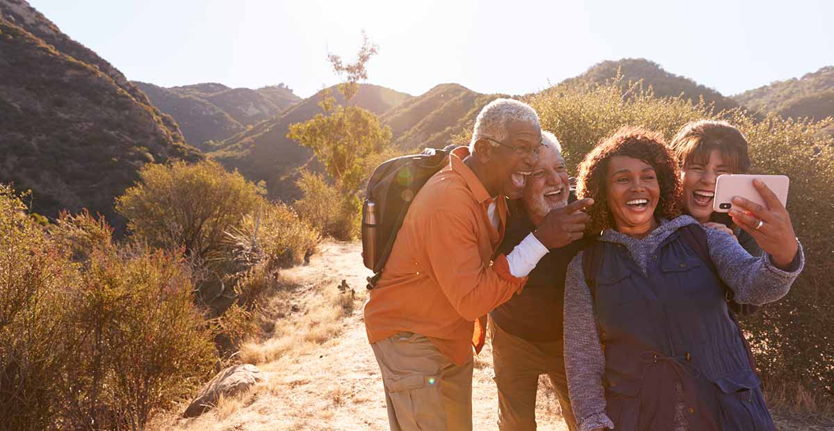 seniors hiking in the mountains take a group selfie
