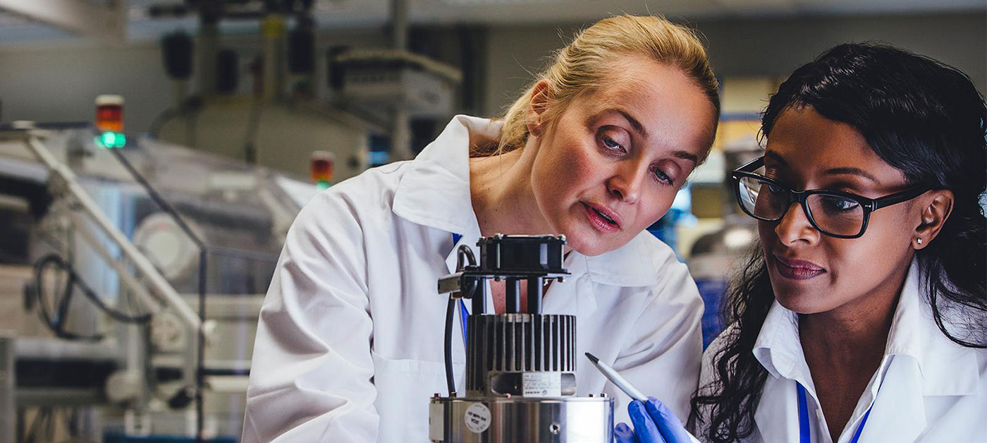 two researchers inspecting a device