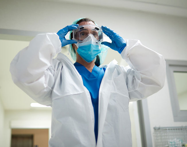 medical worker puts on personal protective equipment