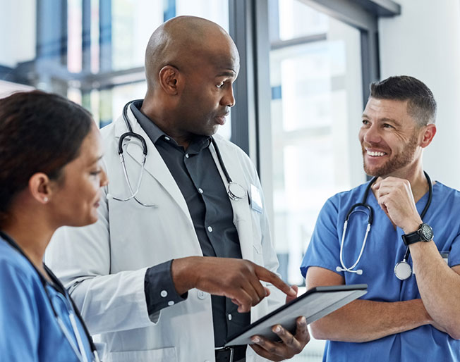 a doctor speaking with two RNs