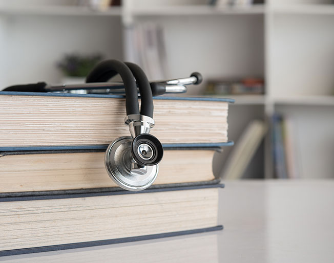 stack of books with stethoscope