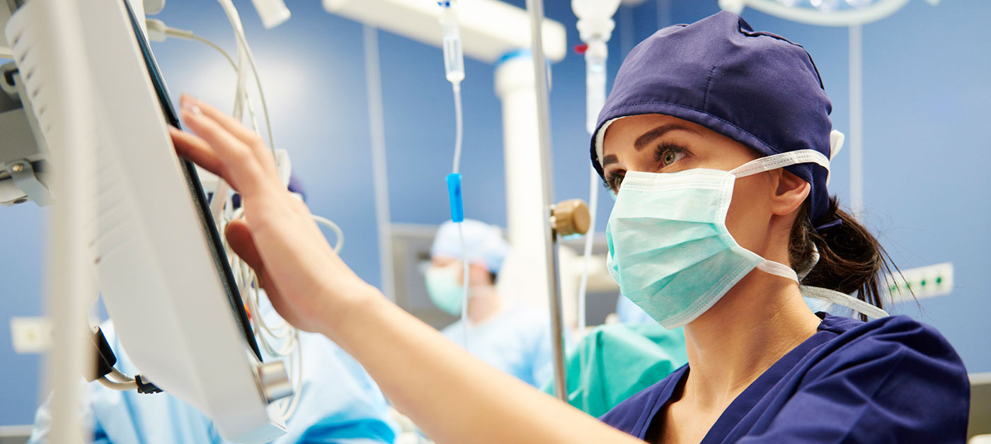 nurse consults screen in operating room