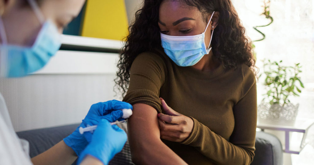 woman of color receives vaccination