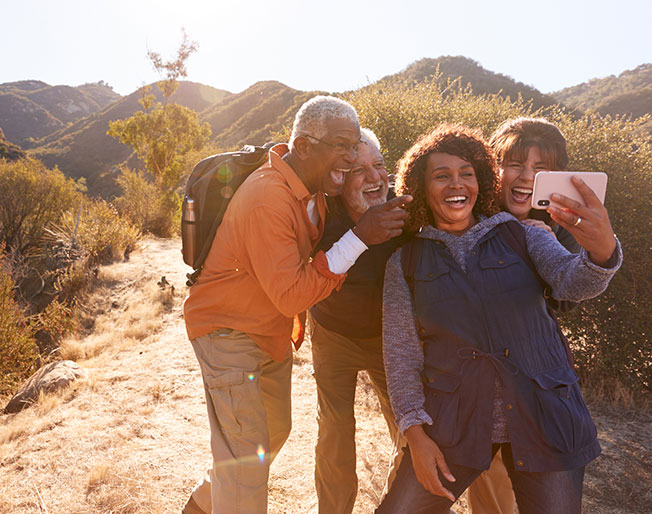 four hiking seniors take selfie