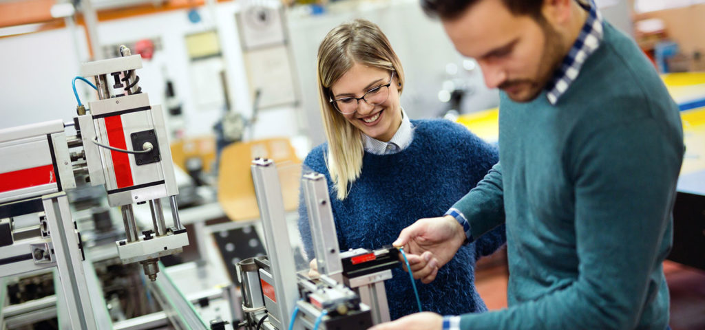 two young scientists tinker on machinery