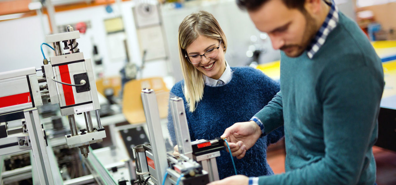 two young scientists tinker on machinery