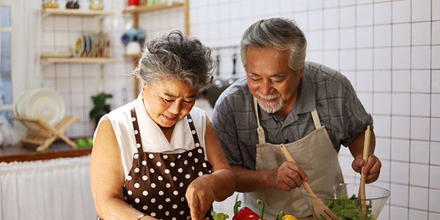 couple cooking healthy food in their kitchen