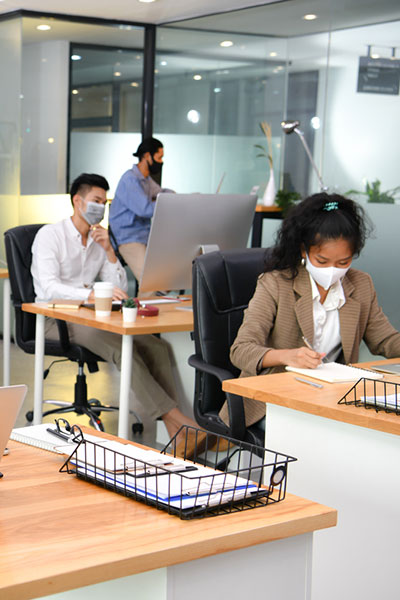 colleagues work in office wearing face masks