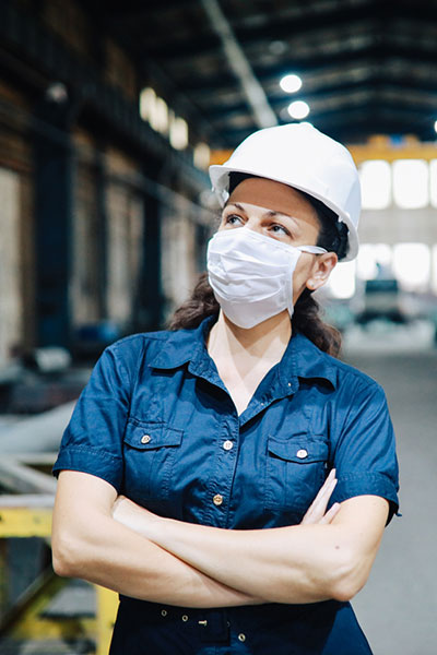 a masked manufacturing worker in a warehouse