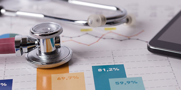 stethoscope and calculator rest on data graphs