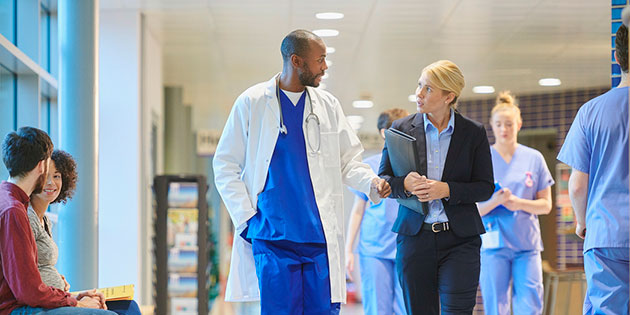 doctor and professional walking and talking through hospital