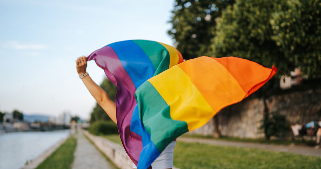 person carrying PRIDE flag