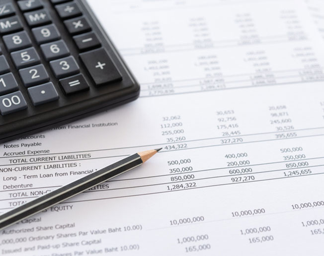 calculator and pencil rest on balance sheet