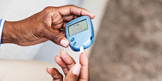 hands using diabetes glucose monitor