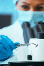 doctor examines implantable device with tweezers