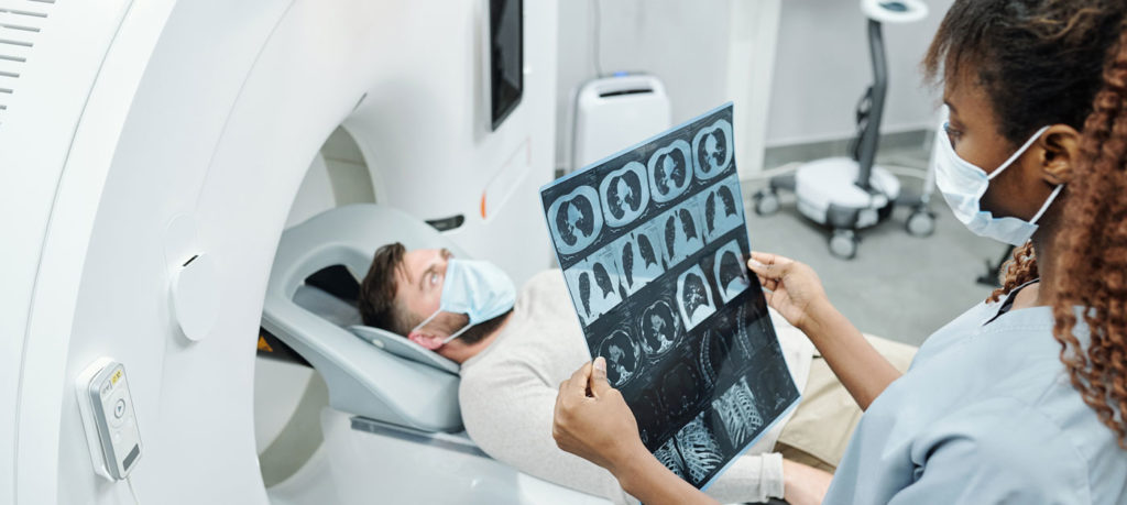technician reviews results of mri scan next to patient