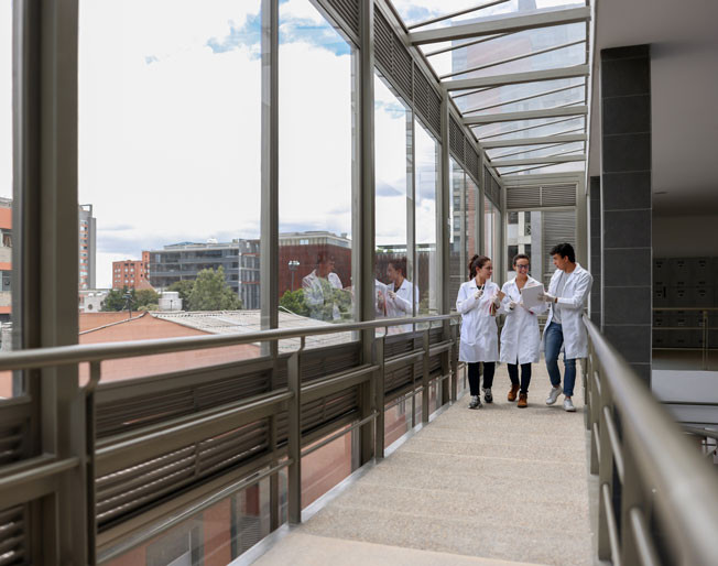 three healthcare workers walk the hall of a hospital