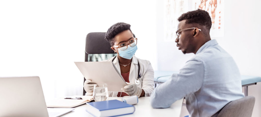 a doctor speaks with a patient showing them files