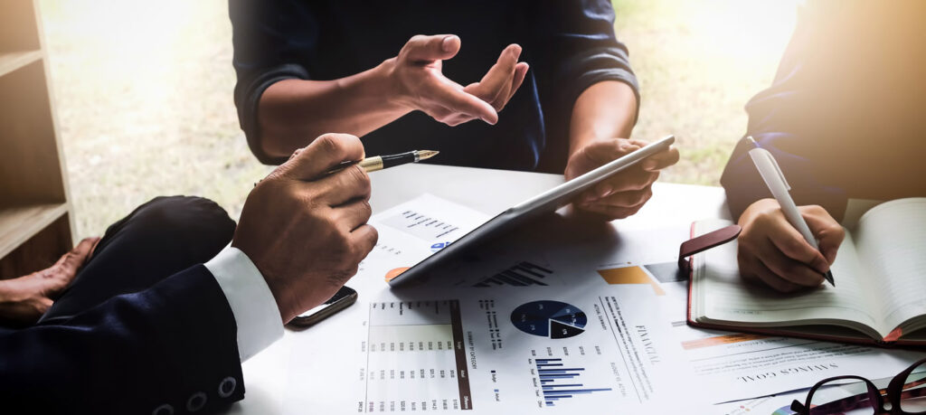 three seated people discuss investments