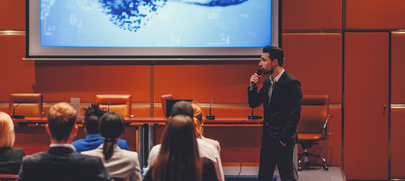 gentleman gives presentation to group in conference room