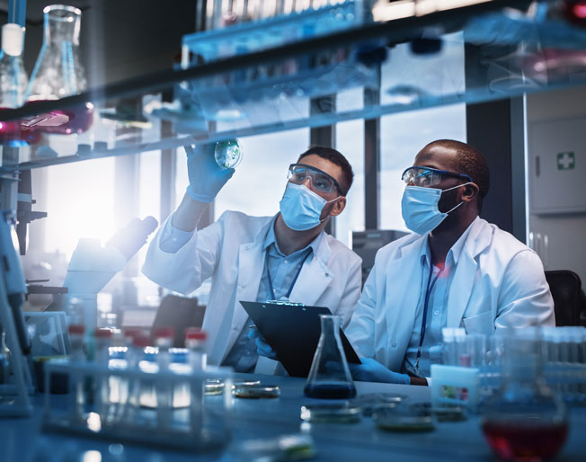 two scientists examine a petri dish in a lab