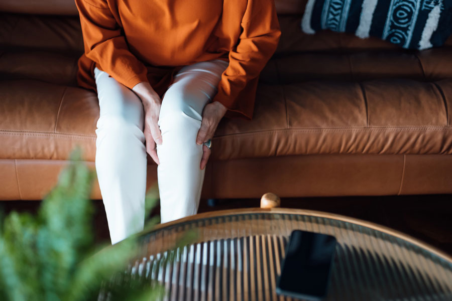 woman on couch holding knee