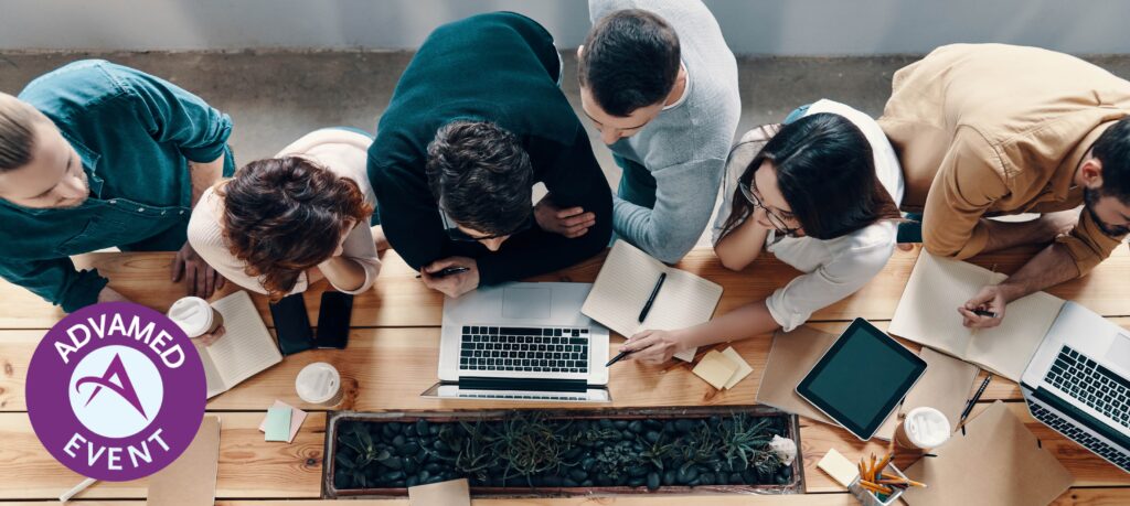 Young professionals discussing and looking at a laptop.