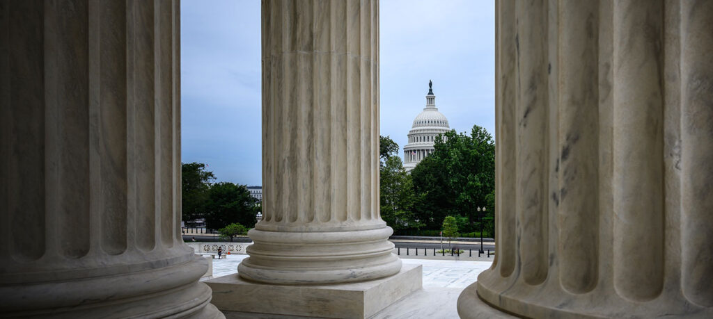 capitol dome viewed at a distance between columns