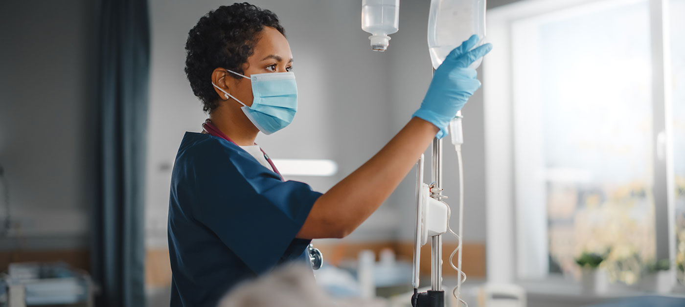 nurse checks an IV drip bag
