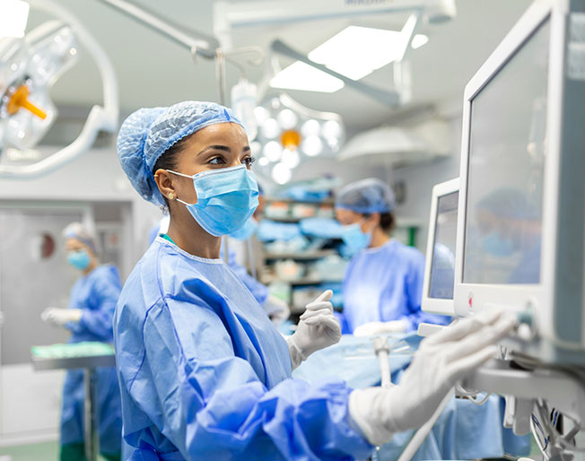medical professional consults monitor in operating room