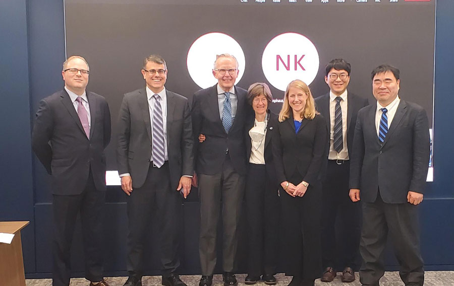 portrait of seven smiling people in a conference room