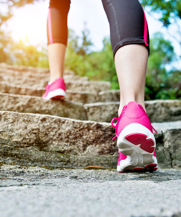 feet in sneakers walking up outdoor stairs