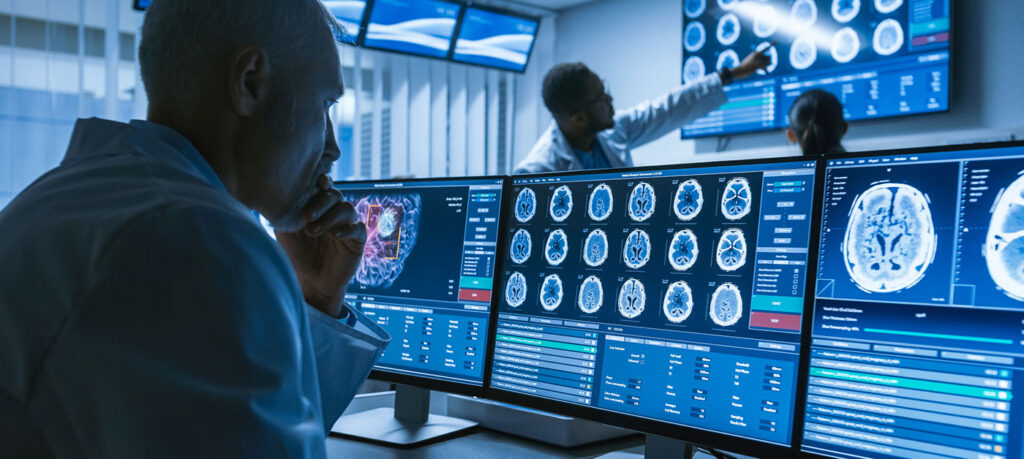 scientists in lab coats examine MRI images of brains