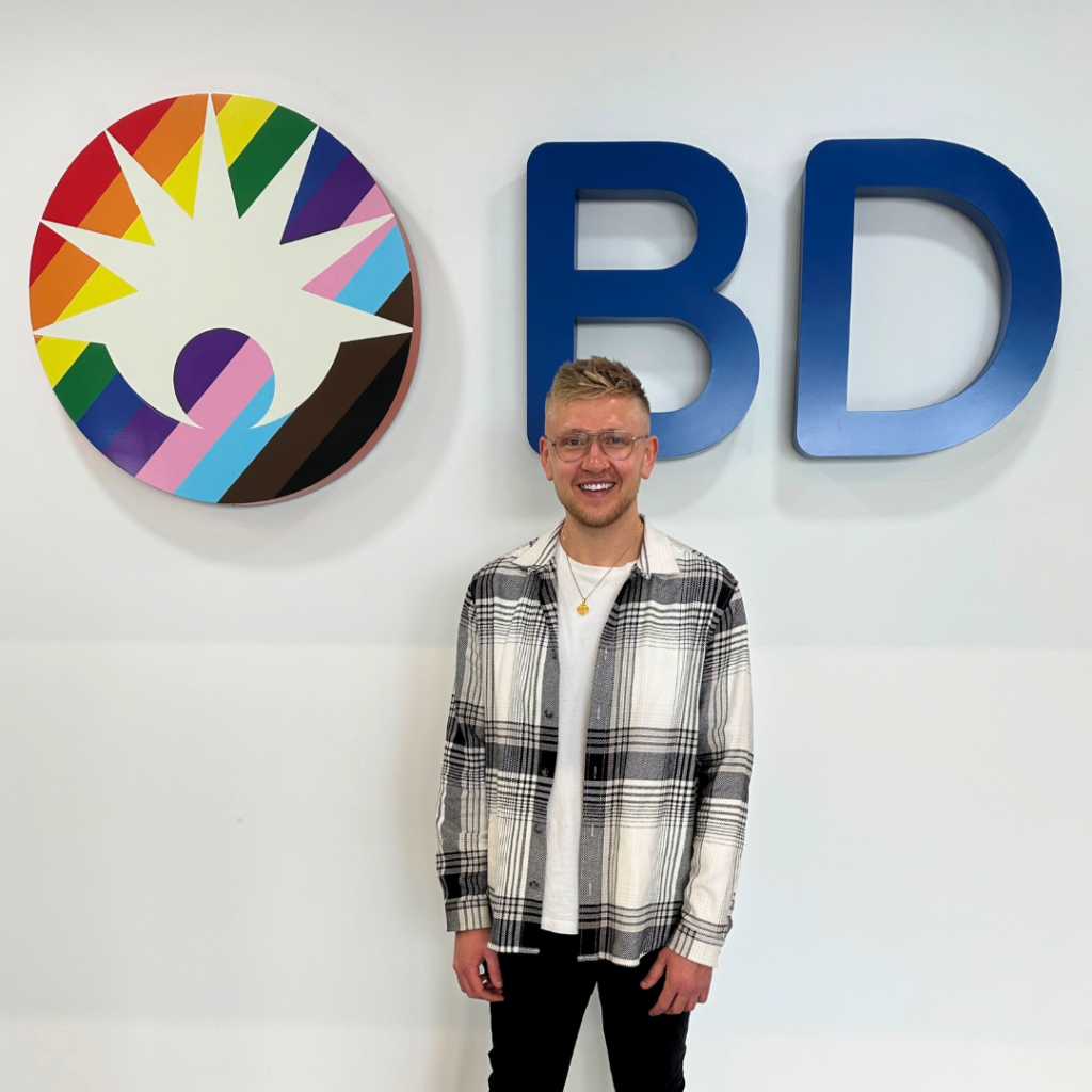 Picture of Ben Redgell standing in front of BD sign