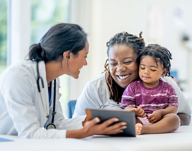 mother and child patients laughing with doctor