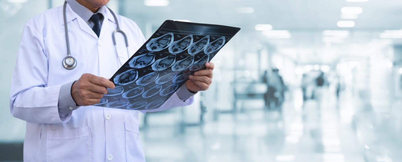 Orthopedic surgeon doctor examining patient's knee joint x-ray films