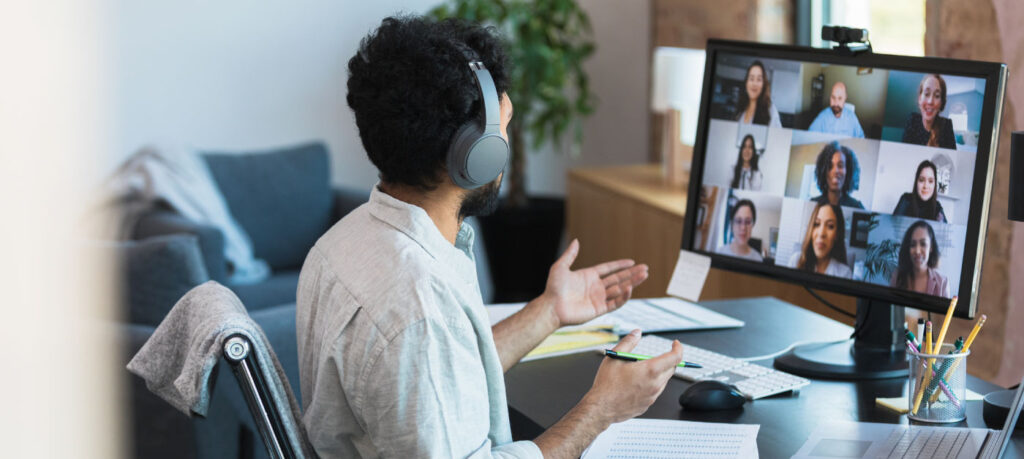 A businessman explains something to a group of colleagues during a video call