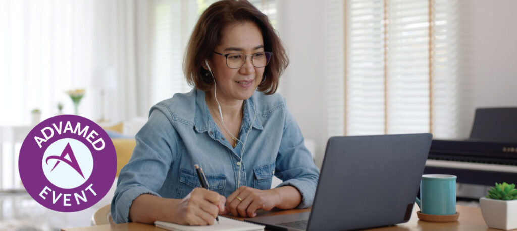 Woman sitting in front of a laptop with headphones in listening to a webinar while taking notes in a notebook