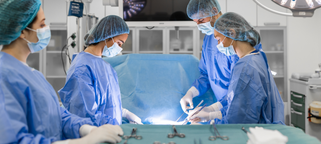 Team of doctors performing operation in surgery room.