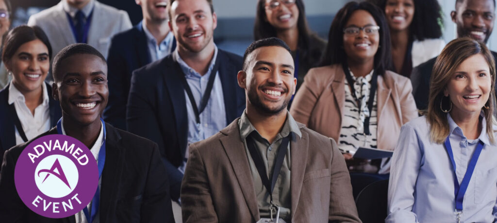 A group of people sitting at an event and listening to a speaker
