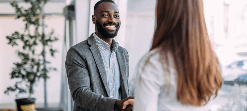 Business people shaking hands in the office. Business persons handshaking during a meeting in modern office.